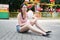 Cute caucasian girl in amusement park is eating pink candyfloss. Portrait of happy attractive young woman with cotton candy.