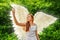 Cute caucasian girl with angel wings and in a white dress