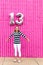 Cute caucasian girl celebrating her 13th birthday teenager standing in front of a hot pink wall outside