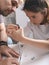 Cute caucasian girl and her beautiful father are assembling furniture with a screewdriver. Housework. Front view. Vertical shot.