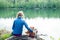 Cute Caucasian little girl on the lake with her plush toys, teddy bear and bunny. Back view. Best Friend Concept