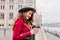 Cute caucasian woman in gray hat laughing with eyes closed in cold spring morning. Outdoor shot of good-looking european