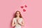 Cute caucasian woman with red hair on pink background