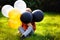 Cute charming boy with colorful balloons in the outdoor park. The kid is enjoying the game. Happy birthday, festive celebration. A