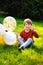 Cute charming boy with colorful balloons in the outdoor park. The kid is enjoying the game. Happy birthday, festive celebration. A