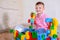 Cute cheeky young boy playing with building blocks