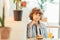 cute cheerful curly boy sitting in cafe in cafe with piece of cake