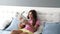 cute cheerful little girl curly hair in bedroom having fun with toy relaxing in bed, weekend