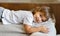 Cute cheerful preschool girl lying on cushioned couch at home