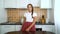 Cute cheerful teenage girl with her hair in braid dancing in the kitchen at home