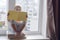 Cute child with books sits near window and looks from above yellow book