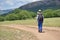 Cute child boy with backpack walking on a little path in mountains. Hiking kid