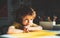 Cute child boy in classroom near blackboard desk. Pupil learning letters and numbers. Children learning.