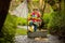 Cute child, boy in colorful jacket, playing with boat and ducks on a little river, sailing and boating. Kid having fun, childhood