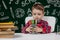 Cute child boy doing homework. Clever kid drawing at desk. Schoolboy. Elementary school student drawing at workplace. Kid enjoy