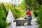 Cute child, boy, playing with boat and ducks on a little rive