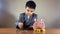 Cute child boy in a suit counting coins. Finance education, children savings concept