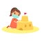 Cute child building sand castle with a face mask.