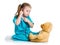 Cute child with clothes of doctor examining teddy bear toy