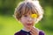 Cute child with dandelion on a green meadow