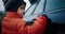 Cute child drawing on the wet car after rain