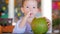 Cute child drinks a coconut trough a straw, close-up. Concept: children, happy childhood, summer, baby, vacation.