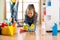 Cute child girl cleanses a floor in nursery at home