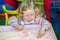 Cute child girl drawing draws developing sand in preschool