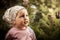 Cute child girl looking dreaming in dark wood among fern with sunlight copy space