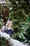 Cute child girl in owl knitted hat on the walk in winter snowy garden