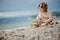 Cute child girl playing and building rock tower on summer beach