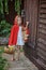Cute child girl plays little red riding hood in summer garden
