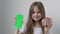 Cute child girl shows phone with green screen mock up cellphone, mobile, telephone and gift. Chroma key green screen