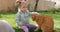 Cute child girl sitting on lawn and her cats in spring backyard garden