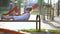Cute child girl waiting for her mother laying on a bench on summer playground in kindergarten yard.