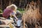 Cute child girl with watering can gathering water from pond