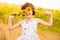 Cute child girl wear dress with sunflower in summer field. Happy little girl hide eye with sunflower. Summer holidays