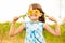 Cute child girl wear dress with sunflower in summer field. Happy little girl hide eye with sunflower. Summer holidays