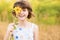 Cute child girl wear dress with sunflower in summer field. Happy little girl hide eye with sunflower. Summer holidays