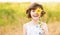 Cute child girl wear dress with sunflower in summer field. Happy little girl hide eye with sunflower. Summer holidays