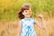 Cute child girl wear dress with sunflower in summer field. Happy little girl hide eye with sunflower. Summer holidays