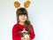 Cute child girl wearing Rudolf hat and holding beautiful gift