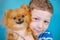 Cute child is hugging with love his lovely pet dog pomeranian