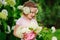 Cute child with hydrangea flowers bouquet in summer garden near flowering bush
