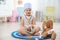 Cute child imagining herself as doctor while playing with stethoscope and toy bunny