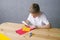 Cute child makes a card out of quilling, glue a strip of paper with white glue