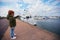 Cute child on the pier looks at the moored yachts in yacht club