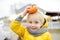 Cute child play with small orange decorative pumpkin. Pumpkin is traditional vegetable used on holidays - Halloween and