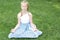 Cute child practicing yoga on the grass outdoors