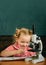 Cute child research with microscope optical instrument at school classroom. Little girl study with microscope at biology